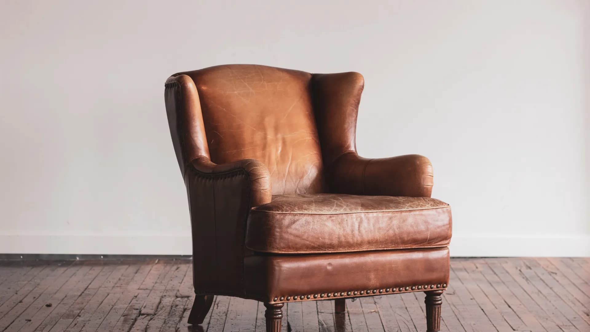 Worn brown leather wingback chair