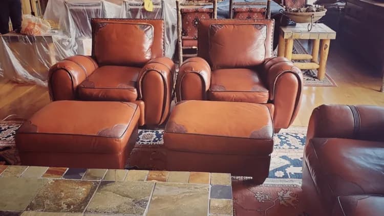 Matching brown leather chairs and ottomans in a furnished room