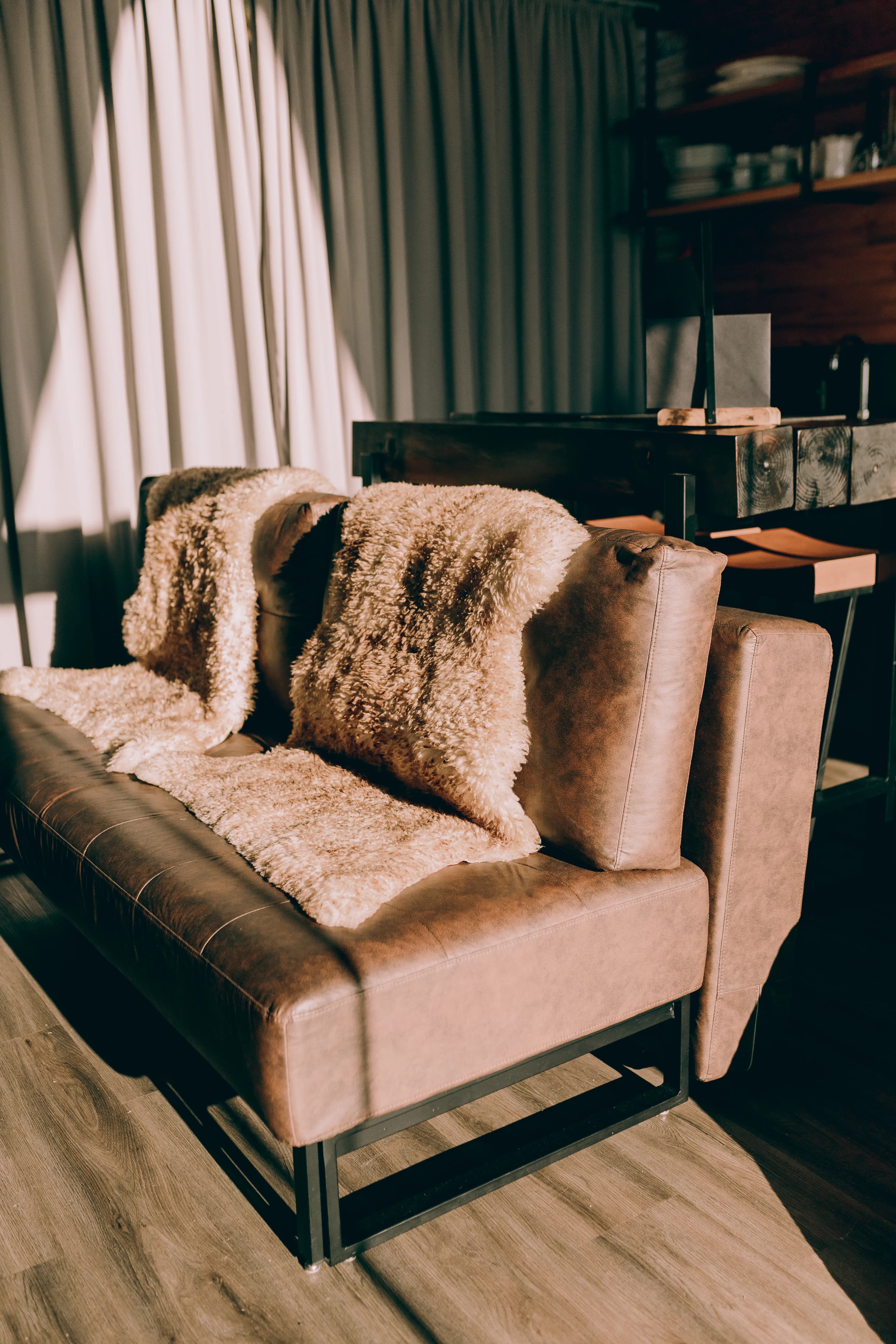 Brown leather lounge chair with a soft throw in a residential interior