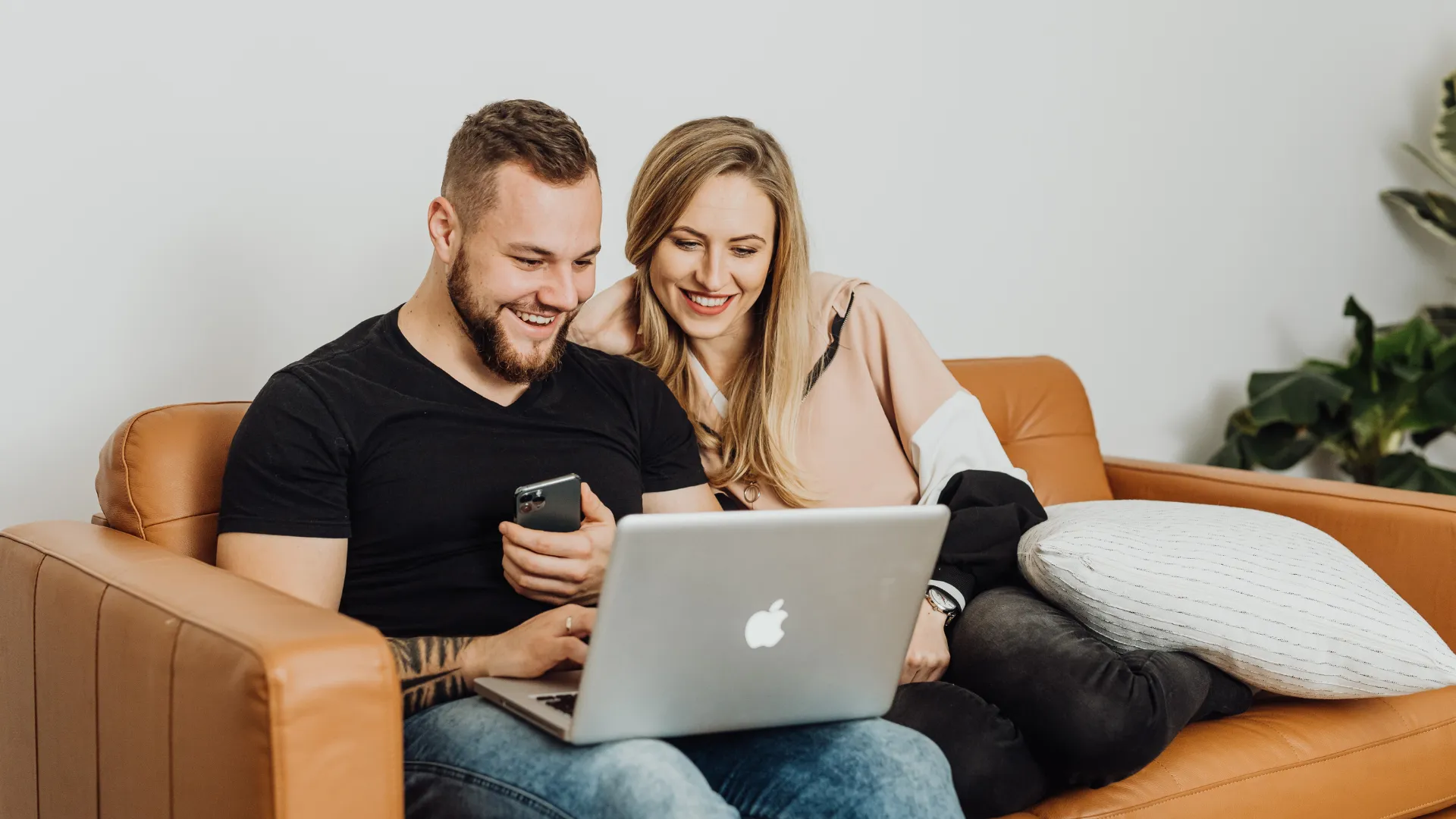 Couple seated on a tan leather sofa in a home