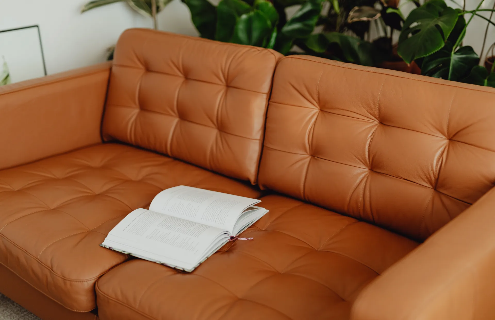 Finished cognac leather sofa with a book on the seat
