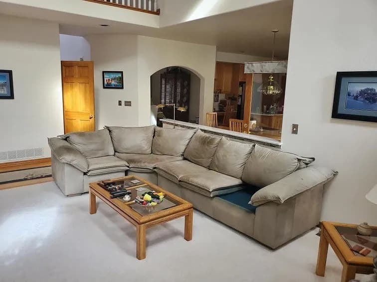 Grey sectional with a seat cushion removed for assessment
